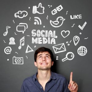 Man in front of blackboard with social media icons on it